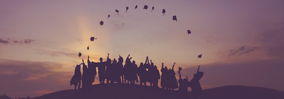 Group of graduates throwing their hats in the air